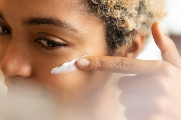 Young woman applying moisturizer