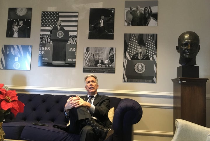 Walsh waits in vain to visit top RNC officials beneath a wall of photos devoted to President Donald Trump.