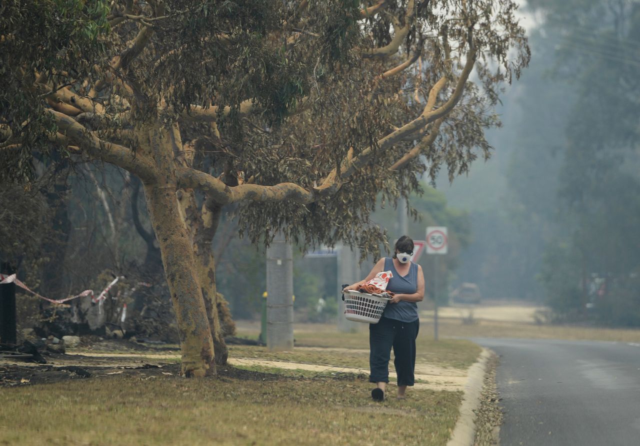 A local walks with smoke mask on in Mallacoota, Victoria.