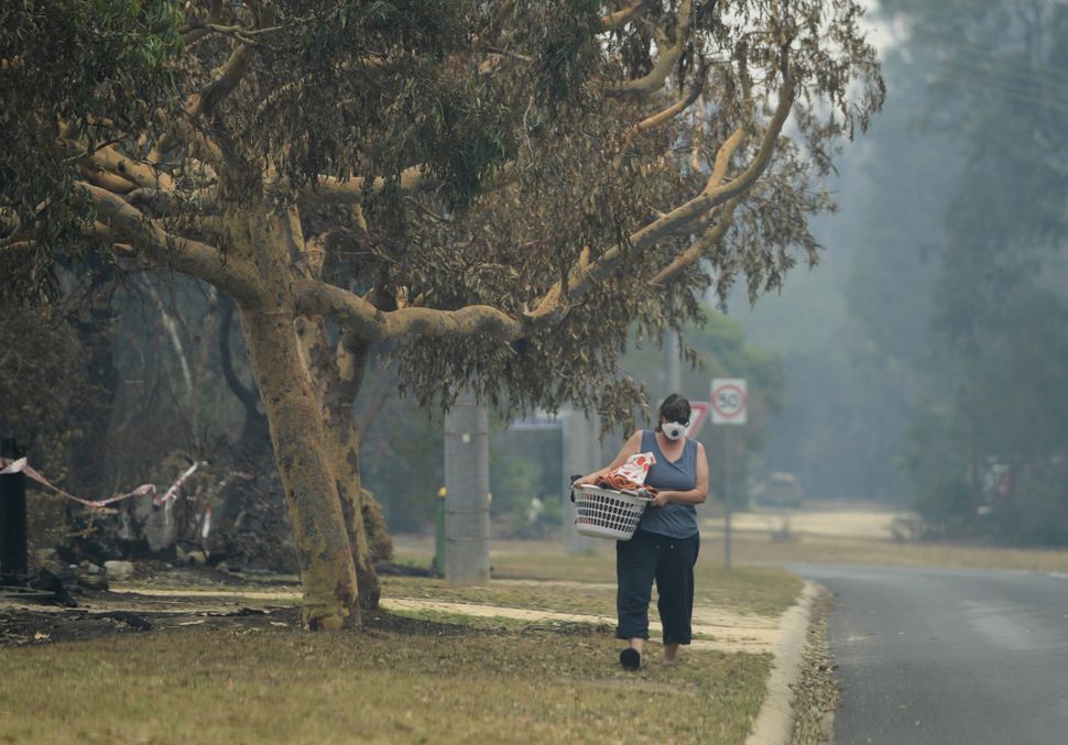 A local walks with smoke mask on in Mallacoota, Victoria.
