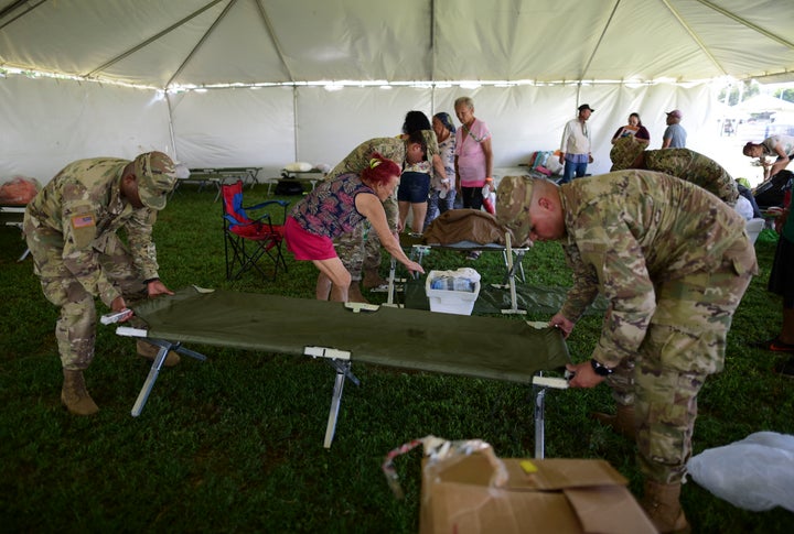 Members of the US army reserve assemble a cot as they set up a tent city to house hundreds of people displaced by earthquakes