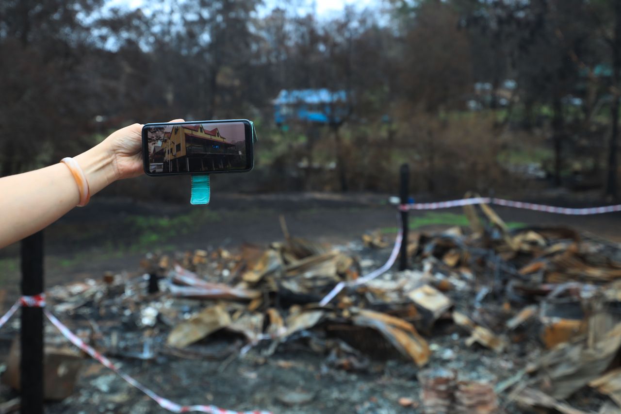 Photo taken on January 18 shows the property picture on its owner's phone taken before the bushfire and its ruins left by the bushfire in Mogo town, a two-hour drive from Canberra, Australia.