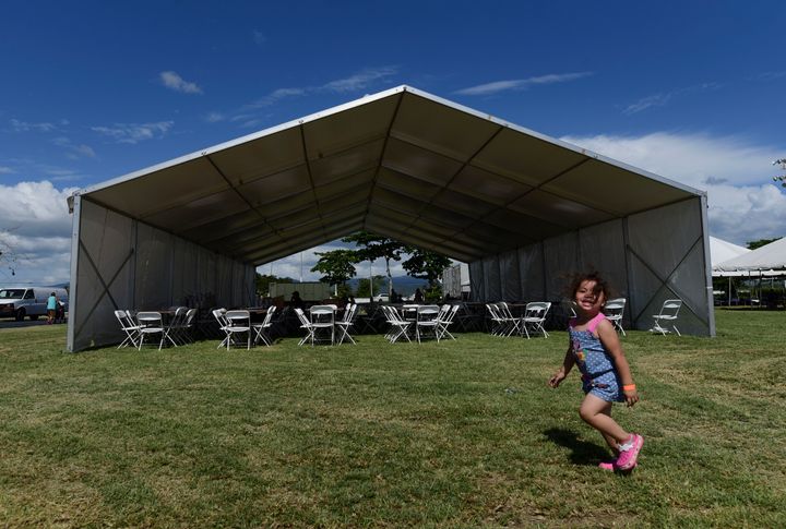 A girls runs on the grounds of a tent city for hundreds of people displaced by earthquakes in Guanica, Puerto Rico, Tuesday, 