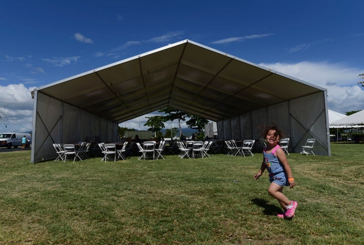 A girls runs on the grounds of a tent city for hundreds of people displaced by earthquakes in Guanica, Puerto Rico, Tuesday,