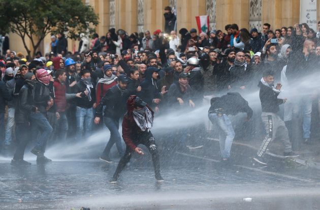 Des manifestants sont frappés par un canon à eau lors d'une manifestation contre une élite...