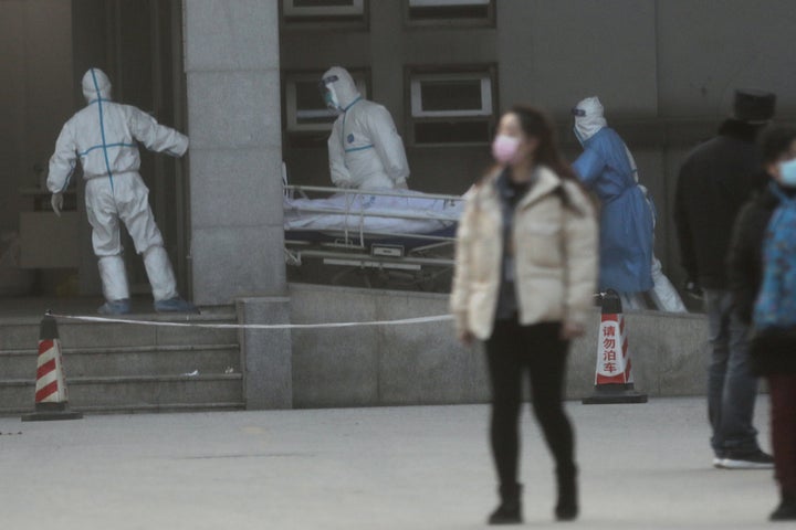 Medical staff transfer a patient at the Jinyintan hospital, where the patients with pneumonia caused by the new strain of cor