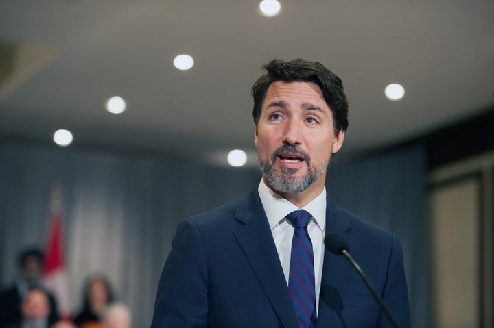 Prime Minister Justin Trudeau stands in front of his cabinet as he speaks to media during the final day of the Liberal cabinet retreat at the Fairmont Hotel in Winnipeg on Jan. 21, 2020.