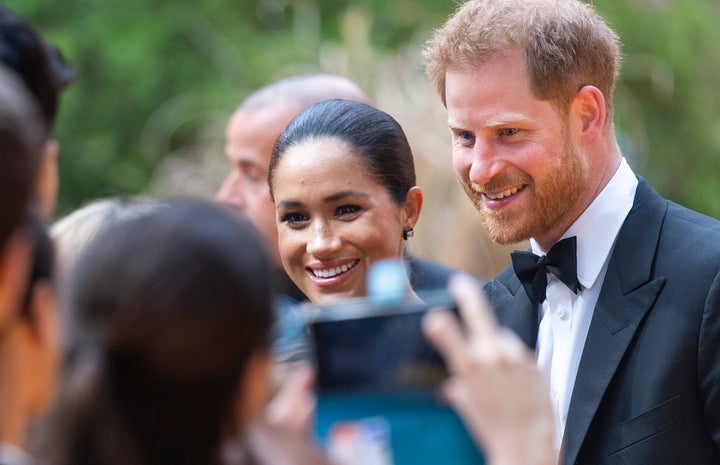 A fan snaps a photo of Meghan and Harry at the London premiere of "The Lion King" on July 14.