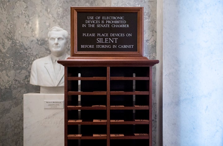 A storage unit for phones stands next to the entrance of the Senate chamber on Tuesday, Jan. 21. Electronic devices are not a