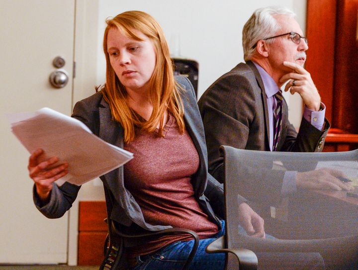 Tilli Buchanan, left, reads a document in court as she sits with Randy Richards, right, her lawyer 