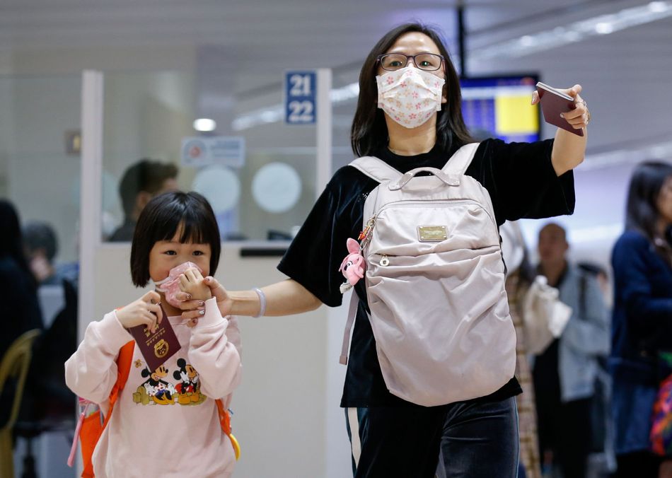 Una mujer y su hija, con mascarillas en el aeropuerto de Manila (Filipinas)