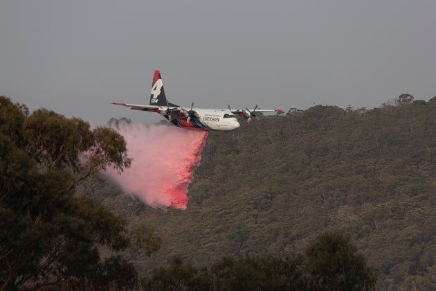 A large air tanker (LAT) drops retardant near a property on January 10, 2020 in Penrose, Australia.