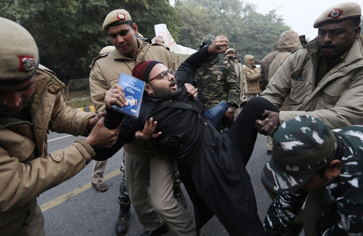 Police officers detain a protesting against the new citizenship law outside Uttar Pradesh Bhawan on Friday, Dec. 27, 2019.