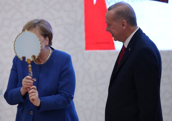 Η Καγκελάριος της Γερμανίας Αγκελα Μέρκελ αντιδρά ξαφνιάζοντας με τον ενθουσιασμό της καθώς δέχεται εθιμοτυπικά δώρα από τον Τούρκο Πρόεδρο Ταγίπ Ερντογάν στην Κωνσταντινούπολη, στις 24 Ιανουαρίου 2020.Tolga Bozoglu/Pool via REUTERS