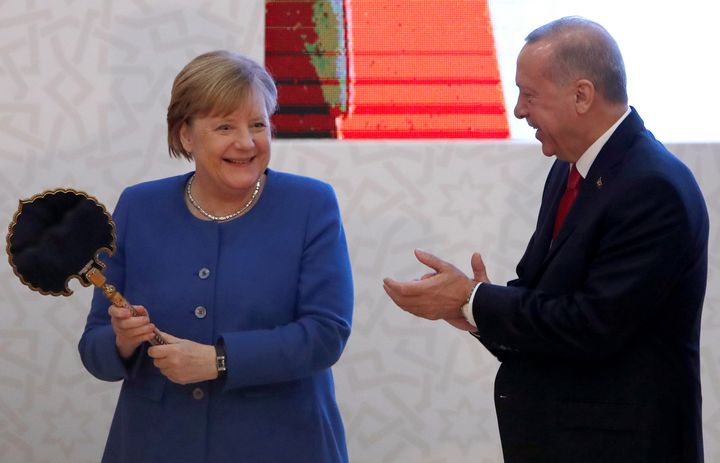 Η Καγκελάριος της Γερμανίας Αγκελα Μέρκελ αντιδρά ξαφνιάζοντας με τον ενθουσιασμό της καθώς δέχεται εθιμοτυπικά δώρα από τον Τούρκο Πρόεδρο Ταγίπ Ερντογάν στην Κωνσταντινούπολη, στις 24 Ιανουαρίου 2020. REUTERS/Umit Bektas