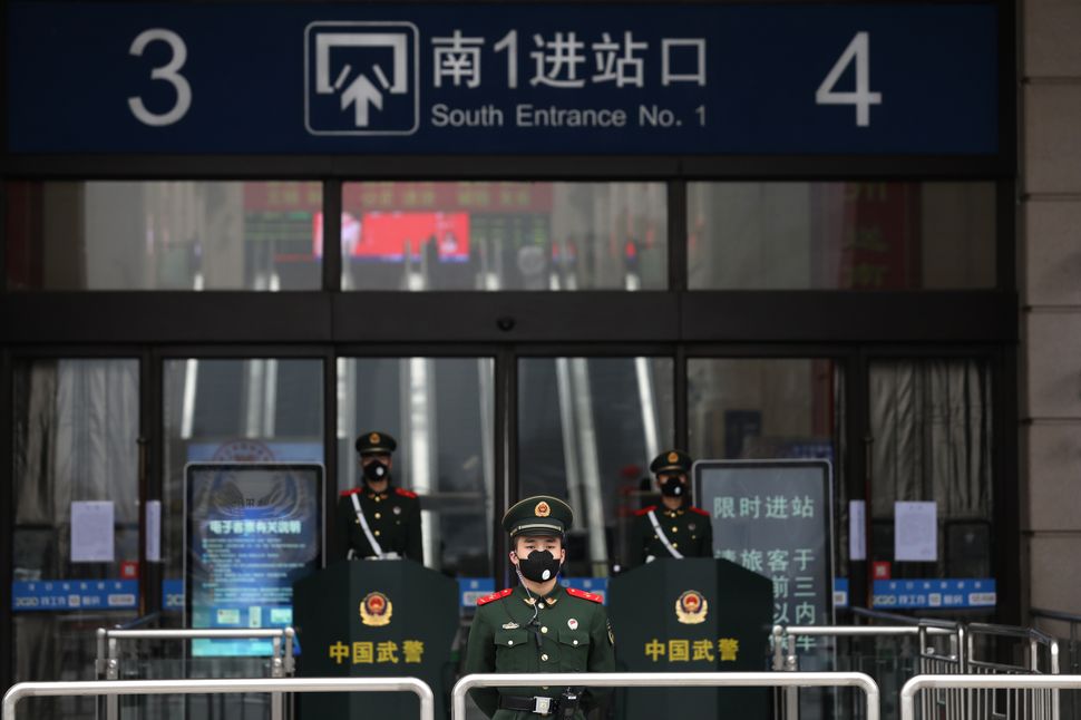Paramilitary policemen guard outside the closed Hankou Railway Station