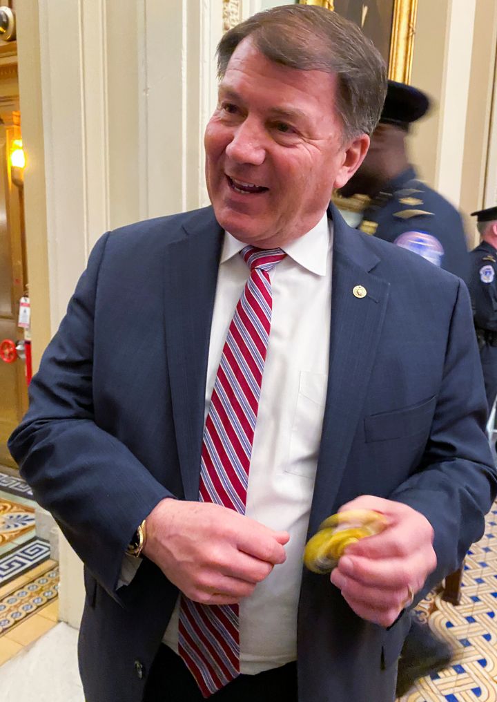 Senator Mike Rounds plays with a fidget spinner handed out to Republican senators at lunch to keep them occupied during the Senate impeachment trial of President Donald Trump 