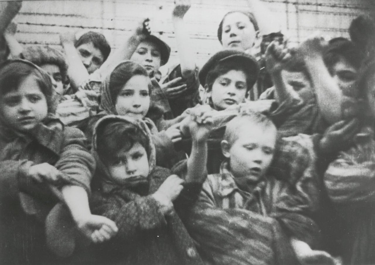 The children in the Auschwitz-Birkenau concentration camp in showing their tattooed numbers on their arms after liberation