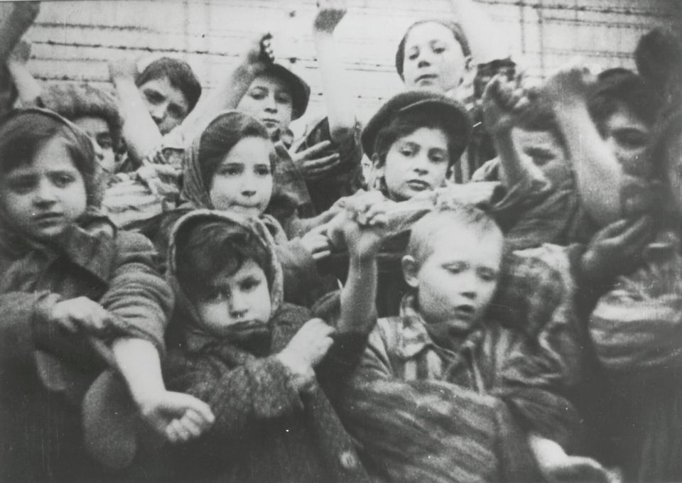 The children in the Auschwitz-Birkenau concentration camp in showing their tattooed numbers on their arms after liberation 