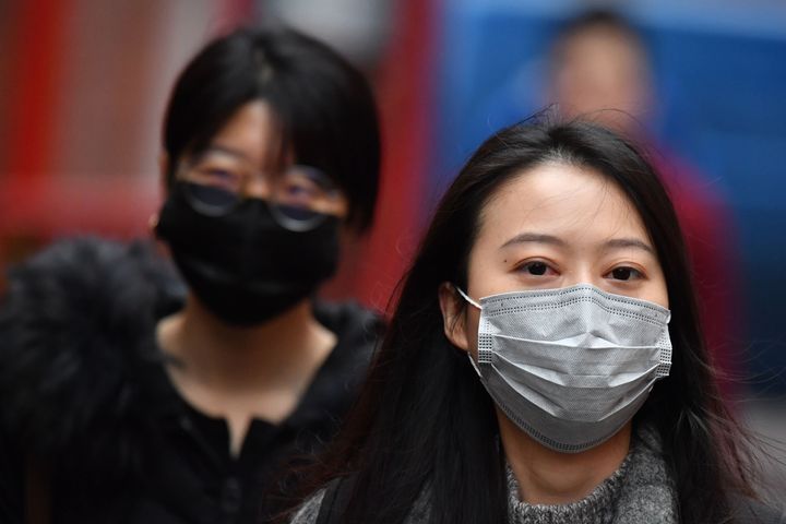 Des piétons portent des masques dans le quartier chinois de Londres, le 24 janvier 2020 (photo d'archives)
