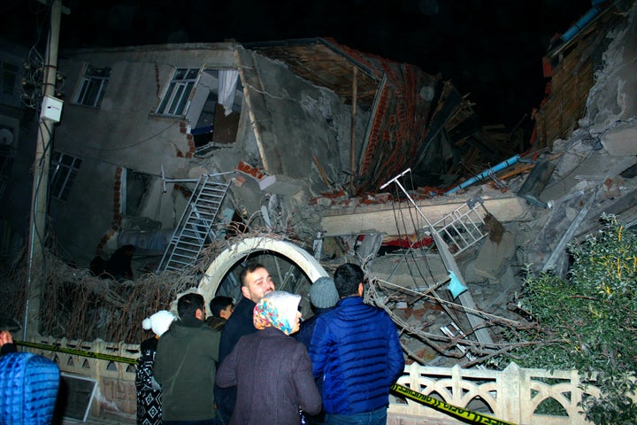 People look at a collapsed building after a 6.8 earthquake struck Elazig city centre in the eastern Turkey on Friday.