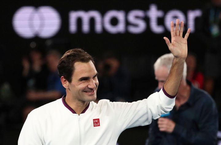 Switzerland's Roger Federer waves after defeating Hungary's Marton Fucsovics in their fourth round singles match at the Australian Open tennis championship in Melbourne, Australia, Sunday, Jan. 26, 2020. (AP Photo/Dita Alangkara)