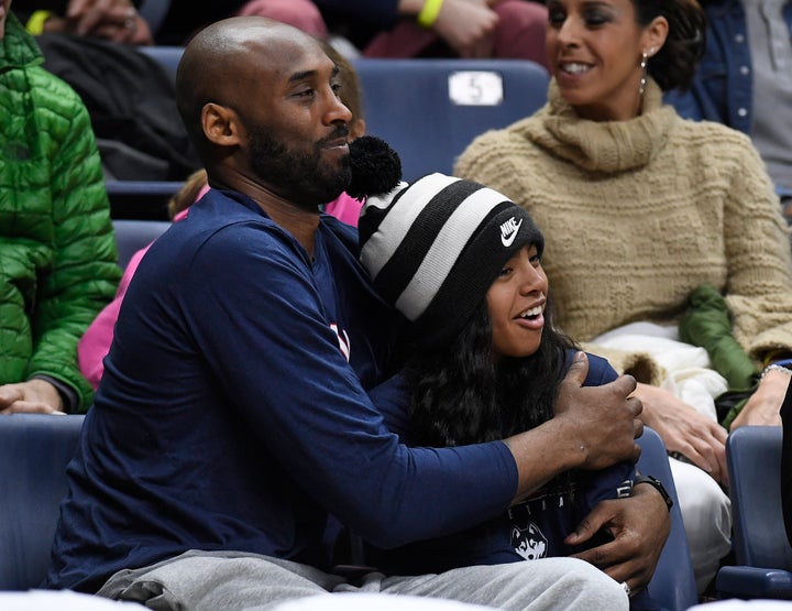 Kobe Bryant and his daughter Gianna watch the first half of an NCAA college basketball game between Connecticut and Houston, Saturday, March 2, 2019, in Storrs, Conn. (AP Photo/Jessica Hill)