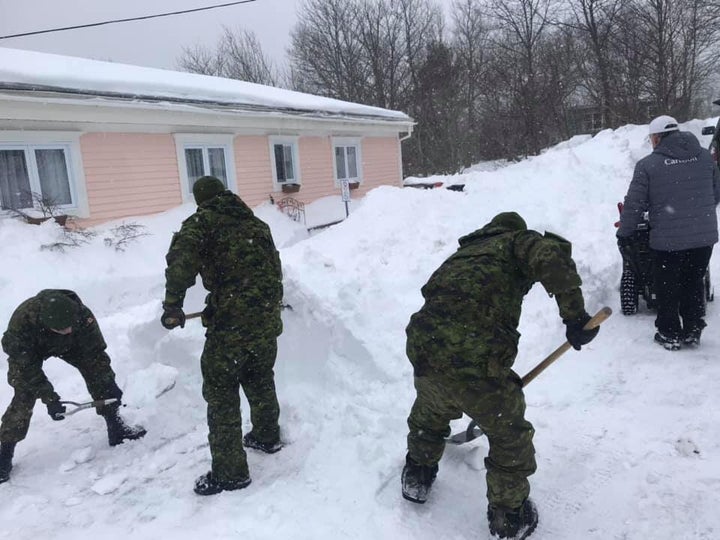 Members of the Armed Forces help clear snow in Newfoundland.