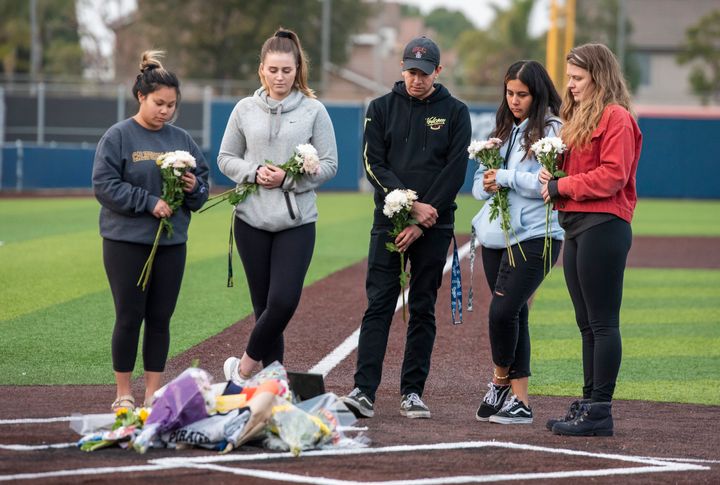 Orange Coast College students and friends of baseball coach John Altobelli lay flowers at home plate at the Orange Coast College baseball field in Costa Mesa on Sunday, Jan. 26, 2020. Coach Altobelli, his wife Keri and daughter Alyssa were also killed in the helicopter crash.