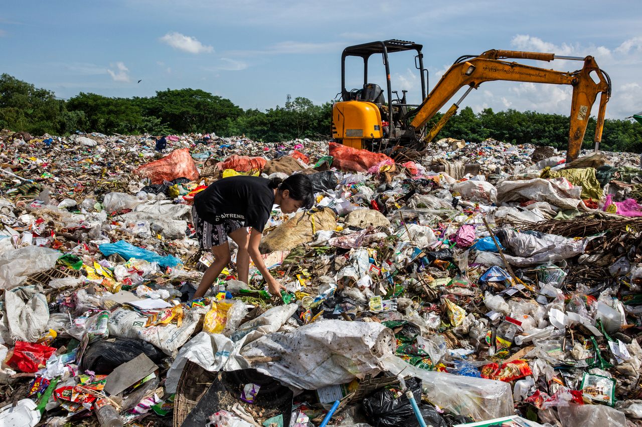 Aye Lay, 19, searches for plastic bottles to sell to the recycle shop at the Dala dump site, Yangon division, Myanmar. She has been working as a plastic collector for seven years.