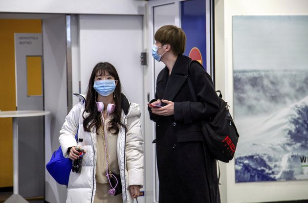 Air travellers wear masks as they arrive at Ivalo Airport, Finland January 24, 2020. On Thursday, two...
