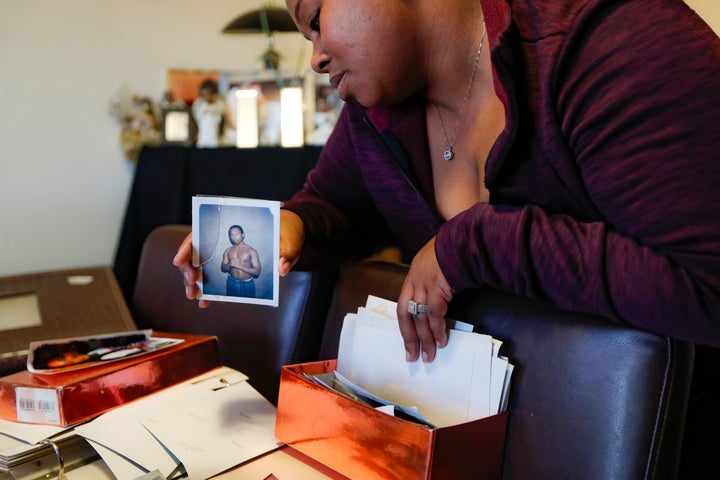 Ianna Burrell holds a photograph of her brother during his first year in prison as she pours over documents at her home, Friday, Oct. 25, 2019, in Shakopee, Minn. (AP Photo/John Minchillo)