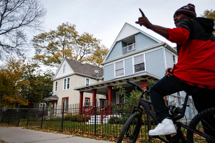 A pedestrian stops outside the former home, in blue, of Tyesha Edwards, an 11-year-old girl pierced in the heart by a stray b