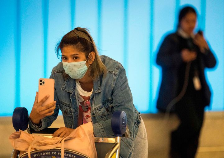 Passengers wear protective masks hoping to protect against the coronavirus as they arrive at Los Angeles International Airport on Jan. 22, 2020.