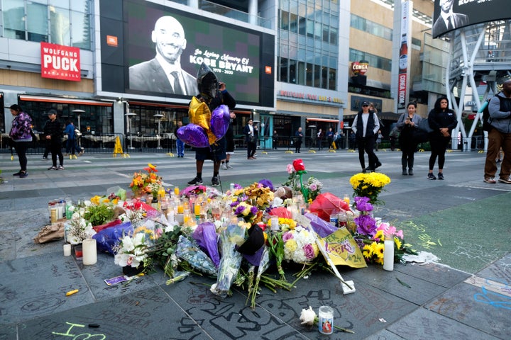 Flowers and candles are placed at a memorial for Kobe Bryant near Staples Center Monday, Jan. 27, 2020, in Los Angeles. Bryant, the 18-time NBA All-Star who won five championships and became one of the greatest basketball players of his generation during a 20-year career with the Los Angeles Lakers, died in a helicopter crash Sunday. (AP Photo/Ringo H.W. Chiu)