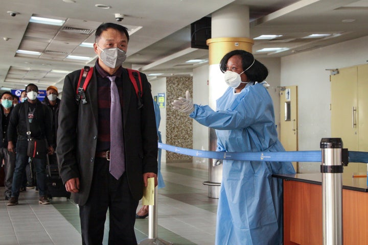 Passengers arriving from a China Southern Airlines flight from Changsha in China are screened for the new type of coronavirus