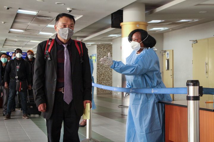 Passengers arriving from a China Southern Airlines flight from Changsha in China are screened for the new type of coronavirus