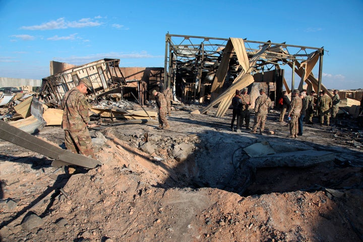 In this Monday, Jan. 13, 2020, photo, U.S. troops stand near their residence area that was destroyed by Iranian bombing at Al