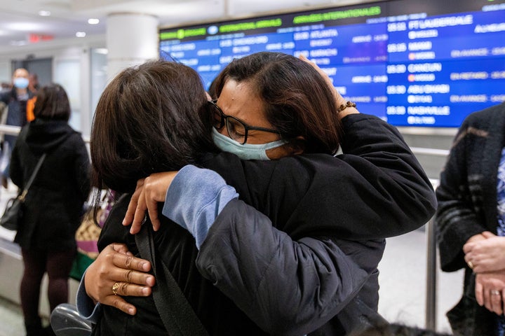 A woman hugs a relative at Toronto Pearson International Airport after arriving on a flight from Hong Kong on Sunday. Companies such as LG and Honda are telling employees to avoid travelling to China.