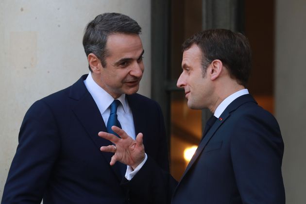 French President Emmanuel Macron (R) and Greek Prime Minister Kyriakos Mitsotakis speak following their...