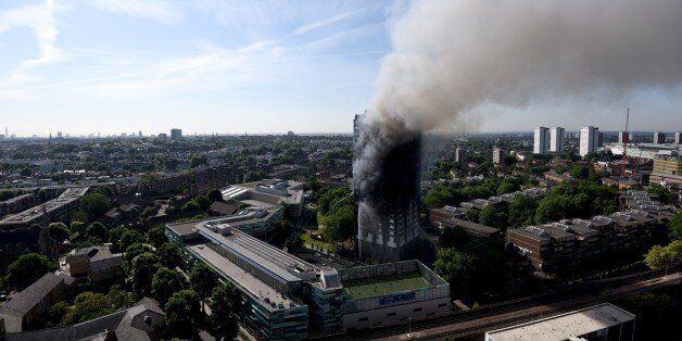 LONDON, ENGLAND - JUNE 14: Smoke rises from the building after a huge fire engulfed the 24 storey residential Grenfell Tower block in Latimer Road, West London in the early hours of this morning on June 14, 2017 in London, England. The Mayor of London, Sadiq Khan, has declared the fire a major incident as more than 200 firefighters are still tackling the blaze while at least 50 people are receiving hospital treatment (Photo by Kate Green/Anadolu Agency/Getty Images)