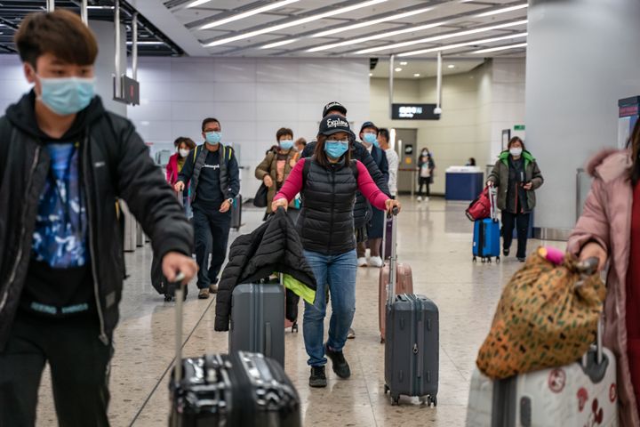 Travellers wearing protective masks exit the arrival hall at Hong Kong High Speed Rail Station on January 29, 2020.
