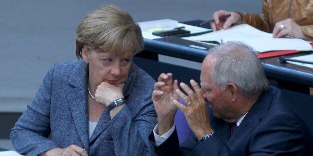 BERLIN, GERMANY - AUGUST 19 : German Chancellor Angela Merkel (L) speaks to German Finance Minister Wolfgang Schauble (R) ahead of voting on a third bailout package for economically-troubled Eurozone member Greece at the German federal parliament, Bundestag, on August 19, 2015 in Berlin, Germany. (Photo by Mehmet Kaman/Anadolu Agency/Getty Images)
