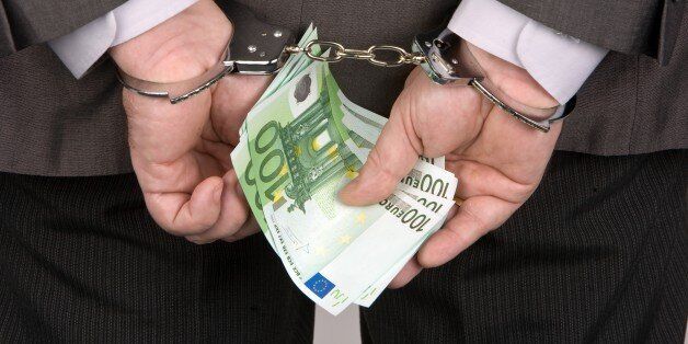 (GERMANY OUT) Germany - : Man with handcuffs holding 100 euro banknotes in his hands (Photo by Wodicka/ullstein bild via Getty Images)
