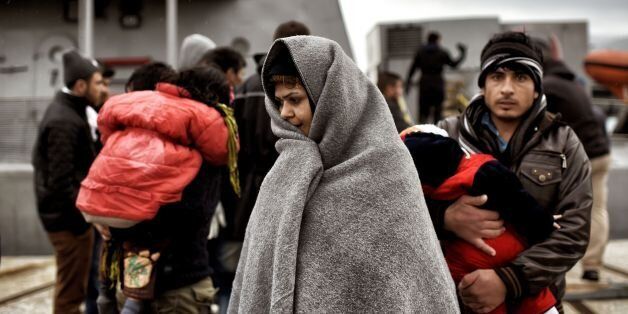 TOPSHOT - Refugees and migrants rescued by the Greek coast guard disembark from a ship upon their arrival in Mytilene on the northern island of Lesbos after crossing the Aegean sea from Turkey on February 19, 2016.The EU and Turkey will hold a special summit in early March to push forward a deal to stem the migration crisis, European Council President Donald Tusk said. / AFP / ARIS MESSINIS (Photo credit should read ARIS MESSINIS/AFP/Getty Images)