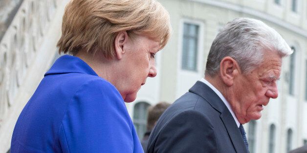 German Chancellor Angela Merkel and German President Joachim Gauck look down prior to the service in the Frauenkirche cathedral (Church of Our Lady) in Dresden, eastern Germany, Monday, Oct. 3, 2016. Germany celebrated the 26th anniversary of its reunification with festivals, concerts and parades across the country. (AP Photo/Jens Meyer)