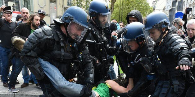 French riot police arrest a man during a demonstration against the French government's proposed labour reforms on April 28, 2016 in Lyon, southeastern France. / AFP / PHILIPPE DESMAZES (Photo credit should read PHILIPPE DESMAZES/AFP/Getty Images)