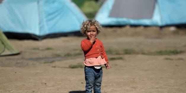 A child stands in the makeshift camp at the Greek-Macedonian border, near the Greek village of Idomeni on March 30, 2016, where thousands of refugees and migrants are stranded by the Balkan border blockade.UN chief Ban Ki-moon on March 30, 2016 called for a united global effort to tackle the Syrian refugee crisis, as he opened a conference on securing resettlement places for nearly half a million of those displaced. More than one million migrants -- about half of them Syrians -- reached Europe via the Mediterranean last year, a rate of arrivals that has continued through the first three months of 2016. / AFP / SAKIS MITROLIDIS (Photo credit should read SAKIS MITROLIDIS/AFP/Getty Images)