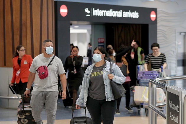 Passengers arriving on flights wear protective masks at the international airport on January 29, 2020 in Auckland, New Zealand.
