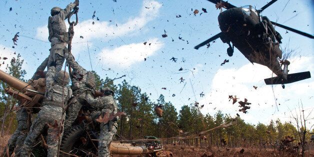 Leaves and twigs are whipped into the air by the rotor wash of UH-60 Black Hawk helicopter as soldiers prepare to hook up an M119A2 105 mm howitzer during air assault training at Fort Bragg, N.C., Feb. 8, 2013. The soldiers are assigned to 3rd Battalion, 319th Airborne Field Artillery Regiment. (DoD photo by Sgt. Michael J. MacLeod, U.S. Army)Date Taken:02.08.2013Location:FORT BRAGG, NC, USRead more: 